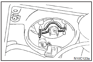 Unhook the spring which secures the bulb, and then remove the bulb.