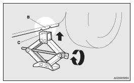 4. Insert the jack bar (D) into the wheel nut wrench (E).