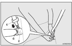 3. Retract the seat belt and remove it from the seat belt guide (A).